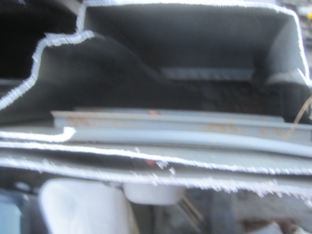 1993 Ford Bronco - The interior of a vehicle is shown, focusing on the dashboard and windshield frame with visible damage to the trim.