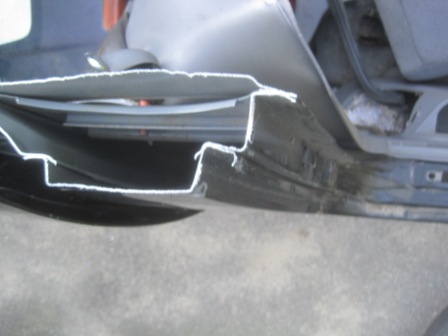 1993 Ford Bronco - Close-up of a damaged vehicle door sill, revealing bent metal and interior components.