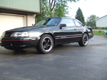 1996 Ford Bronco - A black coupe with red pinstripes and aftermarket wheels is parked in a driveway.
