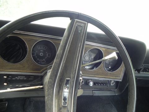1974 Ford Ranchero - The interior of a 1974 Ford Ranchero shows its dashboard with wood grain accents and circular gauges.