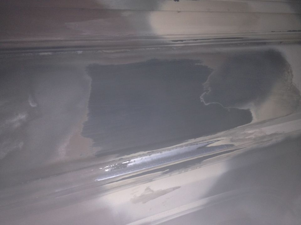 Close-up of a gray interior panel with some discoloration and reflections