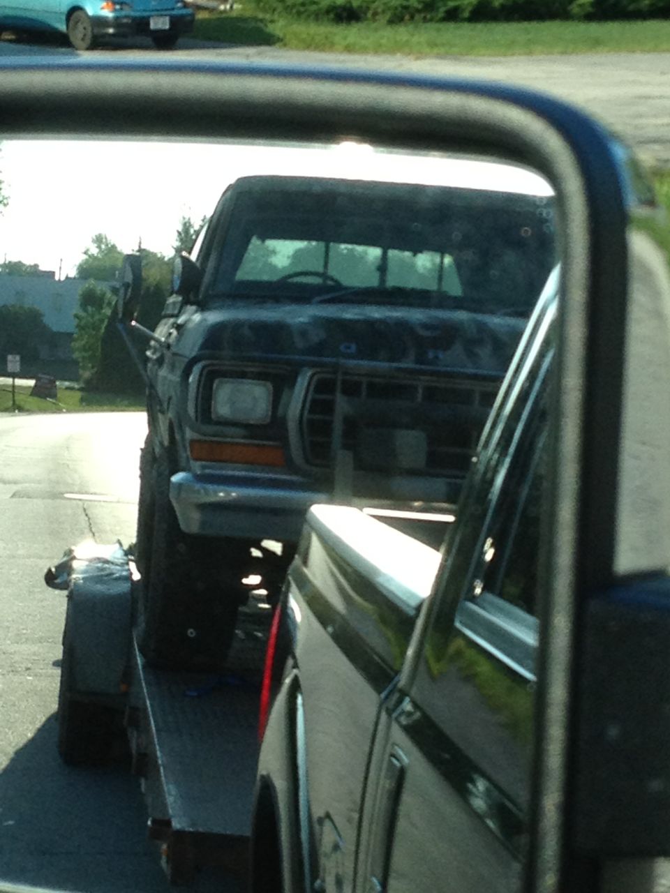 Black 1979 Ford F-350 pickup truck, front view, on a trailer, weathered condition
