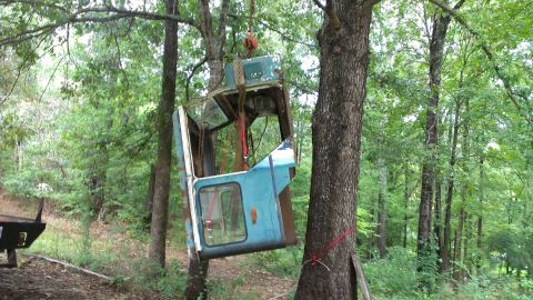 1978 Ford Bronco - A blue truck cab is suspended from a tree branch, with the Supermotors.net logo visible in the lower right corner.