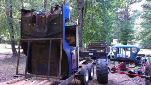 1978 Ford Bronco - Multiple vehicle parts and a truck are visible in this outdoor scene.