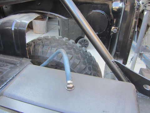 1987 Suzuki Samurai - Close-up of the interior of a vehicle, focusing on the spare tire and roll cage structure.