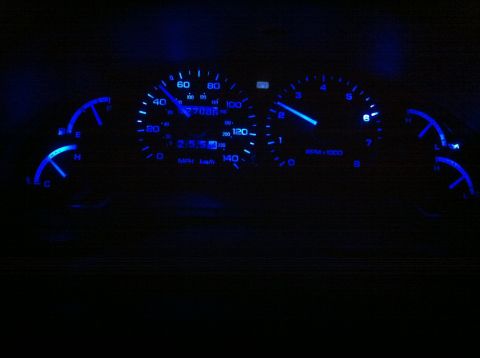 1994 Ford Probe - The illuminated dashboard gauges of a 1994 Ford Probe show the speedometer and tachometer.