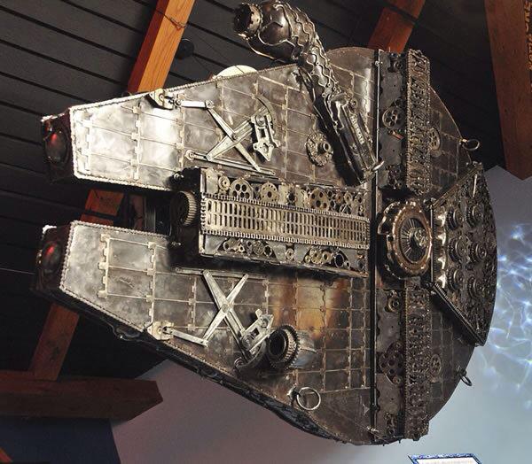 Metal sculpture of the Millennium Falcon hanging from a ceiling