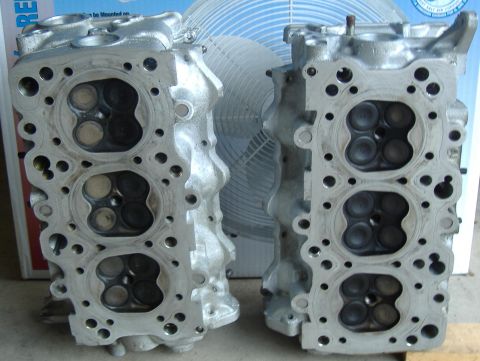 1995 Ford Probe - Two engine cylinder heads are shown, with the one on the right appearing slightly smaller.