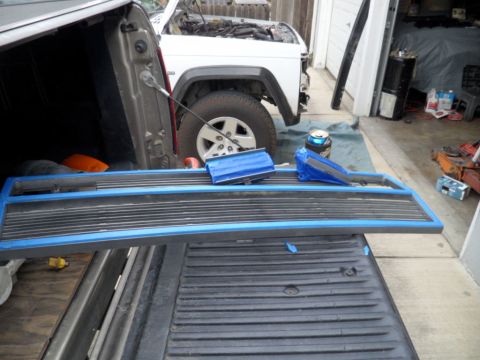 1994 Jeep Cherokee - A Jeep pickup truck tailgate is being prepped for work, with a white Jeep Cherokee visible in the background.