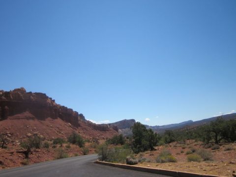 1991 Ford LTD Crown Victoria - Roadside view of a desert landscape with red rock formations and blue sky.