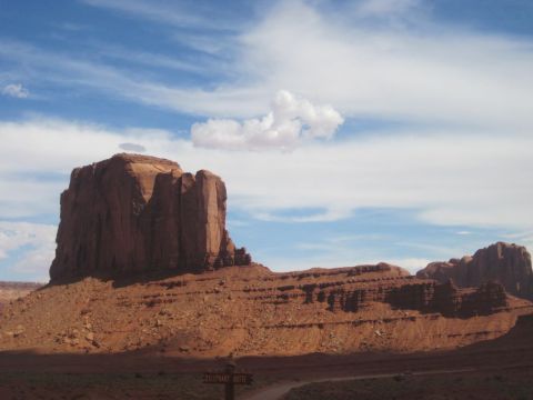 1991 Ford LTD Crown Victoria - Iconic sandstone buttes rise from the desert floor in Monument Valley, Arizona, under a vast sky.
