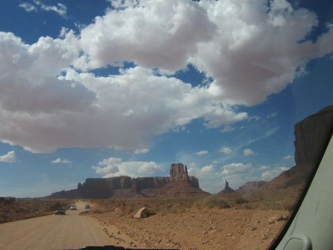 1991 Ford LTD Crown Victoria - Cars travel on a dirt road through the iconic landscape of Monument Valley, Utah.