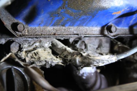 1979 Ford F-350 - A close-up view of an engine's oil pan area, showing worn wiring and grime.