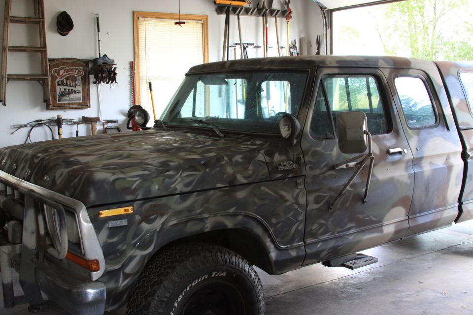 1979 Ford F-350 truck with camouflage paint, parked in a garage