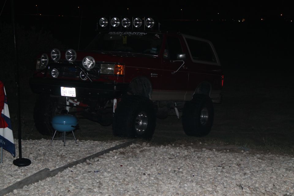 1990 Ford Bronco with multiple off-road lights mounted on the roof and bumper