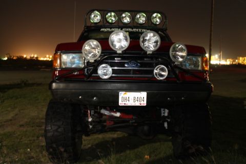 1990 Ford Bronco - This modified Ford truck features an array of auxiliary lights and a prominent light bar on its roof.