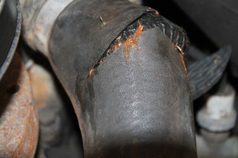 1990 Ford Bronco - A damaged hose shows signs of leakage, indicating a potential mechanical issue.