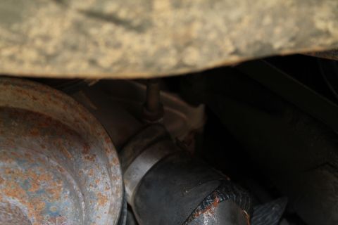 1990 Ford Bronco - Close-up view of vehicle undercarriage components, including rusty metal and hoses, with a SuperMotors watermark visible.