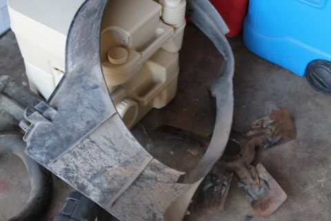 1990 Ford Bronco - A close-up of a dirty plastic shroud and a water jug with caps.