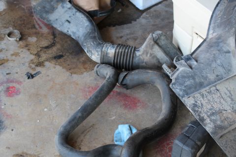1990 Ford Bronco - Air intake components are shown on a dirty concrete surface.