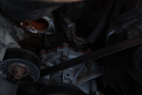 1990 Ford Bronco - Close-up view of engine belts and pulleys, showing wear and rust.
