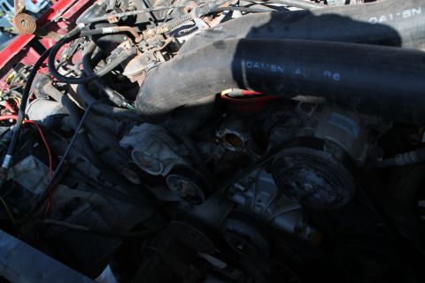 1990 Ford Bronco - A close-up view of a complex engine bay with numerous hoses and mechanical components.