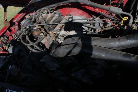 1990 Ford Bronco - Close-up view of a vehicle's engine bay, showing various hoses and mechanical parts.