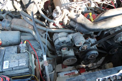 1990 Ford Bronco - A close-up view of a vehicle's engine compartment, showing various mechanical components and wiring.