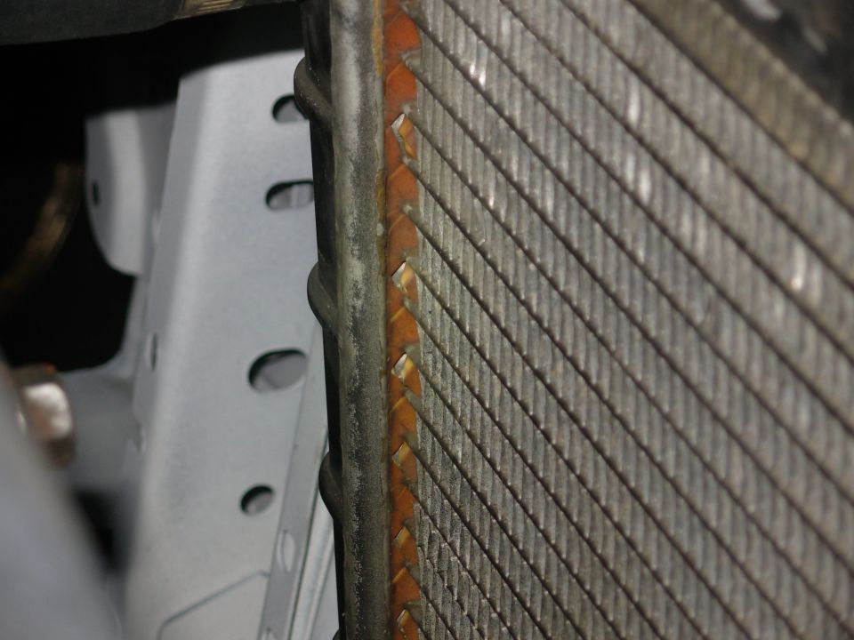 I noticed all these cracks before I bought this junkyard radiator.  But since the truck wasn't wrecked, and there are no signs of coolant leaks or overheating, and they only appear on the rear face of the hot side, I decided they must simply be from the sealant cooking & curling away.  Since it's holding ~12psi right now, they're fine.