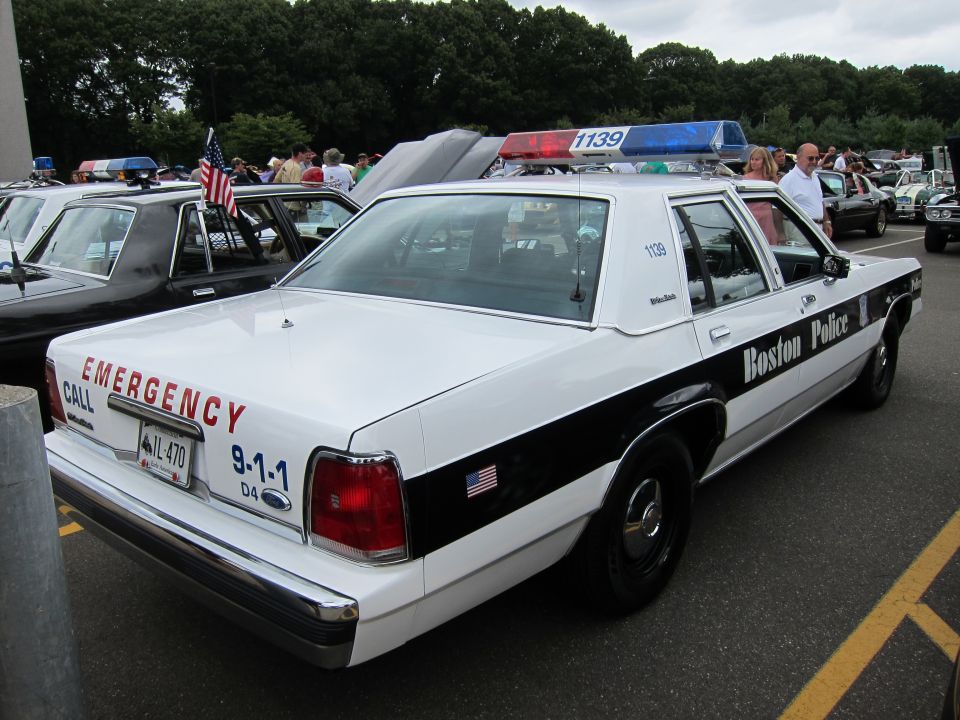 Rear of a black-and-white Boston Police Ford sedan reading Emergency 911