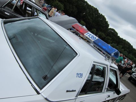 1991 Ford LTD Crown Victoria - Tilted close-up of a white Ford LTD Crown Victoria police car showing rear window, unit number 1139 and roof light bar.