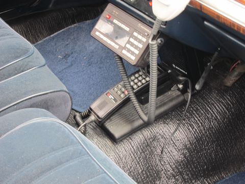 1991 Ford LTD Crown Victoria - Interior shot of a police car floor showing a Motorola two-way radio control head and corded handheld microphone.