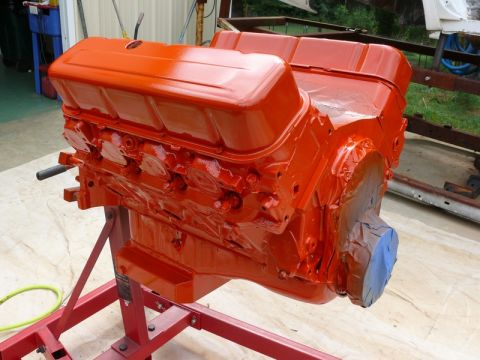 1968 Chevrolet Camaro - Engine block painted bright orange and mounted on a red stand, ready for installation.