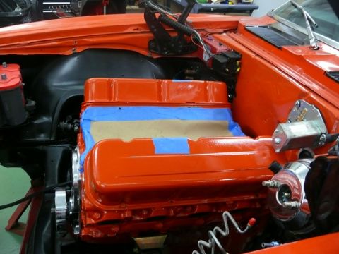 1968 Chevrolet Camaro - Close-up of an orange engine during restoration, with blue tape protecting the valve covers.