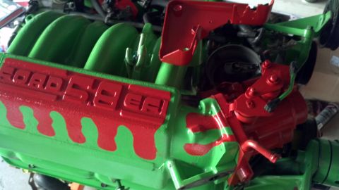 1987 Ford Bronco - Close-up of a Ford 5.8L engine intake manifold, painted in a unique green and red color scheme.