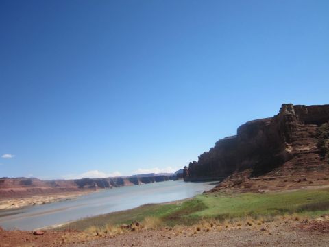 1991 Ford LTD Crown Victoria - Monument Valley landscape a river and red rock formations under a clear blue sky.