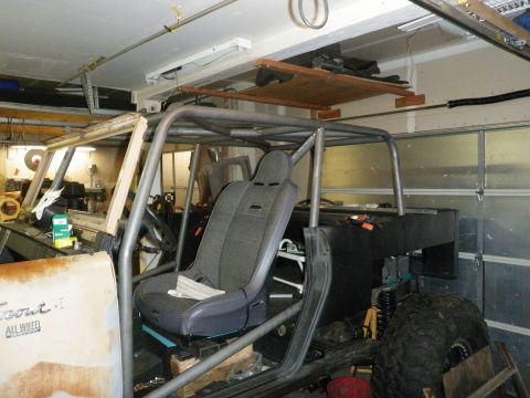 1961 International Scout 800 - Vehicle interior a custom roll cage and racing seat, with visible "Scout II All Wheel" badging on the door.