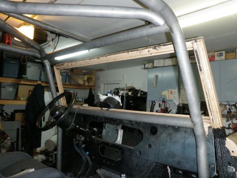 1961 International Scout 800 - The interior of a vehicle is shown with a custom-installed roll cage and unfinished dashboard.