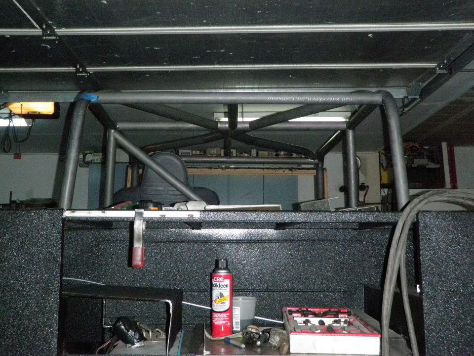 Custom roll cage fabricated from metal tubing, installed in the bed of a pickup truck