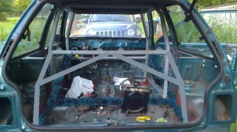 1991 Ford Festiva - The interior of a car has been stripped and fitted with a roll cage, with another vehicle visible outside.