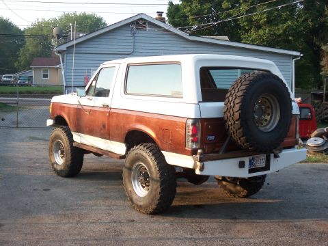 1989 Ford Bronco - This lifted Ford Bronco has a two-tone paint scheme with wood paneling on the lower body.