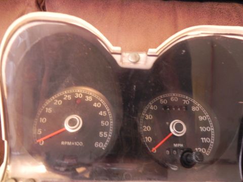 1974 Ford Ranchero - Close-up of vehicle dashboard gauges, including a speedometer and tachometer, showing signs of dust and age.