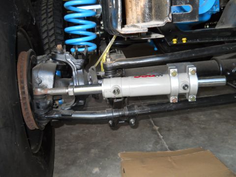 1992 Ford Bronco - This image shows a close-up of a vehicle's steering and suspension components, focusing on a power steering assist cylinder.