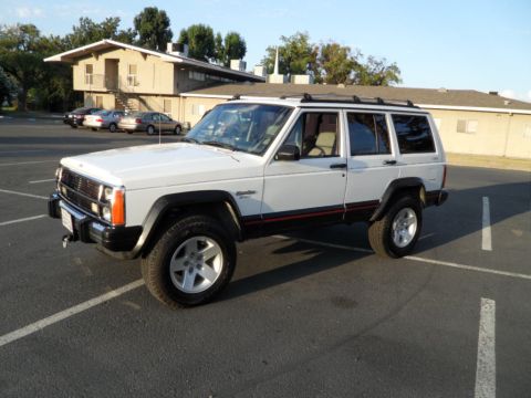 1994 Jeep Cherokee - A white 1994 Jeep Cherokee is shown from a three-quarter front view in a parking lot.