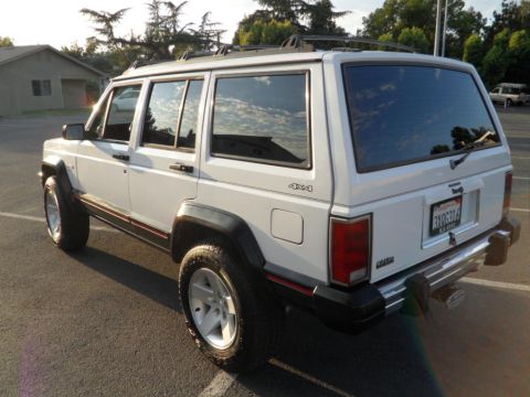 1994 Jeep Cherokee - White 1994 Jeep Cherokee 4x4 SUV parked outdoors, showing its rear quarter and side profile.