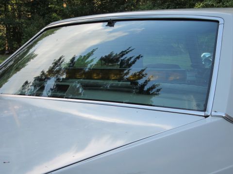 1991 Ford LTD Crown Victoria - The rear of a 1991 Ford Crown Victoria LTD, with reflections visible in the window.