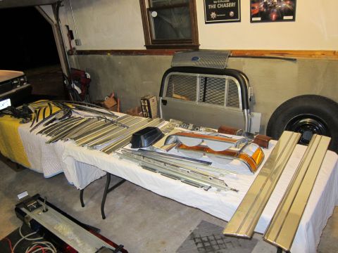 1991 Ford LTD Crown Victoria - Various car parts are organized on tables, suggesting a restoration or repair project.