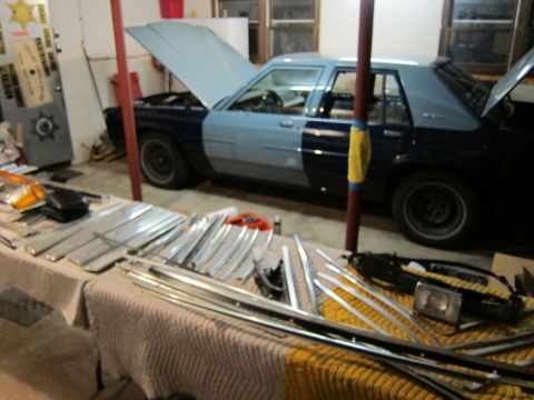 1991 Ford LTD Crown Victoria - 1991 Ford Crown Victoria LTD project car in a garage with parts laid out on a table.
