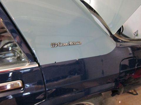 1991 Ford LTD Crown Victoria - Close-up of the 'LTD Crown Victoria' badge on the side of a two-tone Ford sedan, likely a 1991 model.