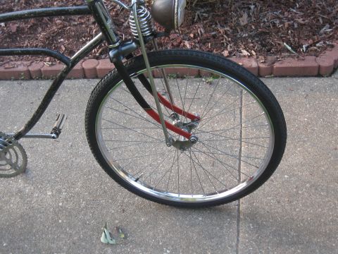 1994 Ford Bronco - Close-up of a vintage bicycle's front wheel and part of the frame, showing its spoked wheel and black handlebars.
